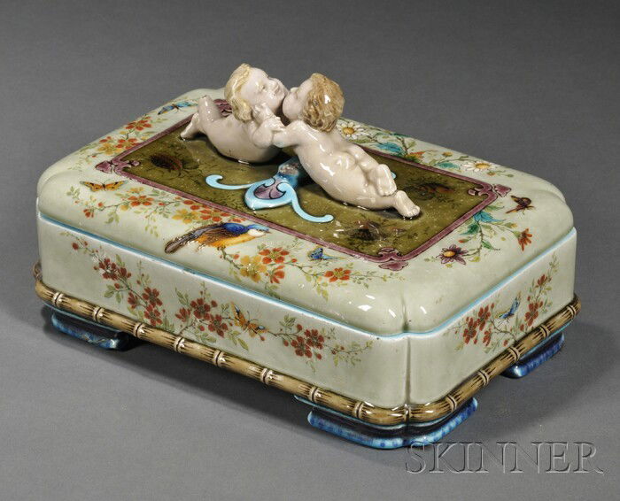 Theodore Deck Ceramic Box, Paris, France, second h: Theodore Deck Ceramic Box, Paris, France, second half 19th century, celadon ground with polychrome enamel decorations of butterflies, birds, and flowers, the handle formed as two embracing putti, on s