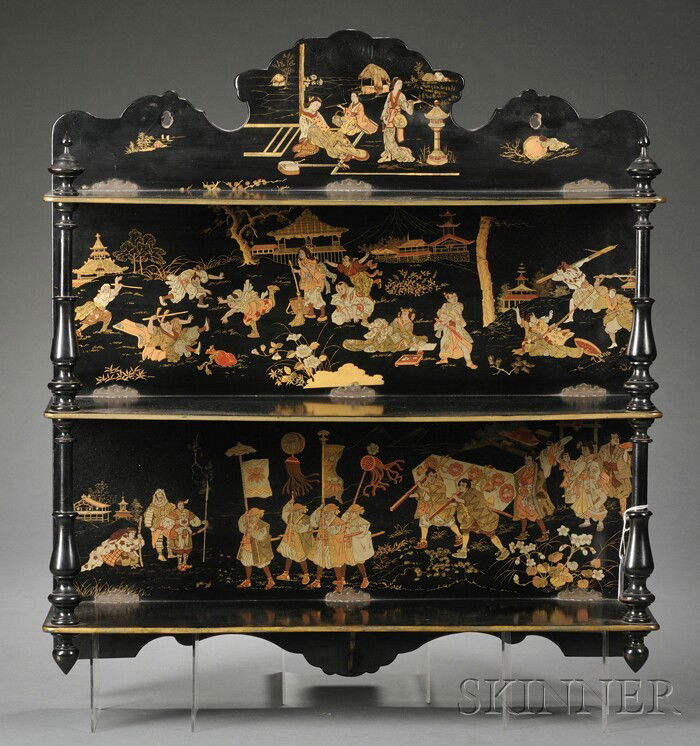 Aesthetic Movement Japanned Hanging Shelf, late 19: Aesthetic Movement Japanned Hanging Shelf, late 19th century, with three shelves on ring-turned supports, the backing printed in tones of gold with a Chinese-style procession and figures in a mock bat