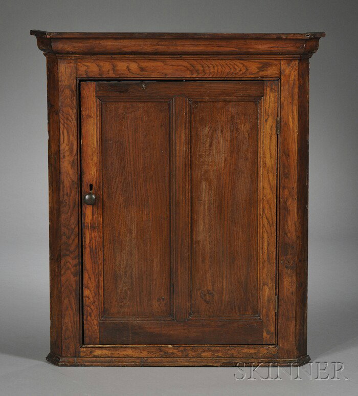 English Provincial Chestnut Hanging Corner Cupboar: English Provincial Chestnut Hanging Corner Cupboard, with antique elements, of typical form, the cornice with ogee profile, single front door enclosing shelves, ht. 51 1/2, wd. 35 1/2, dp. 18 in.
