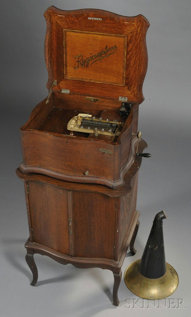 Oak Reginaphone 15 1/2-inch Disc Musical Box, Regi: Oak Reginaphone 15 1/2-inch Disc Musical Box, Regina Music Box Company, New Jersey, c. 1910, serpentine-shaped cabinet with raised lid, matching quarter sawn oak disc storage cabinet below, underside