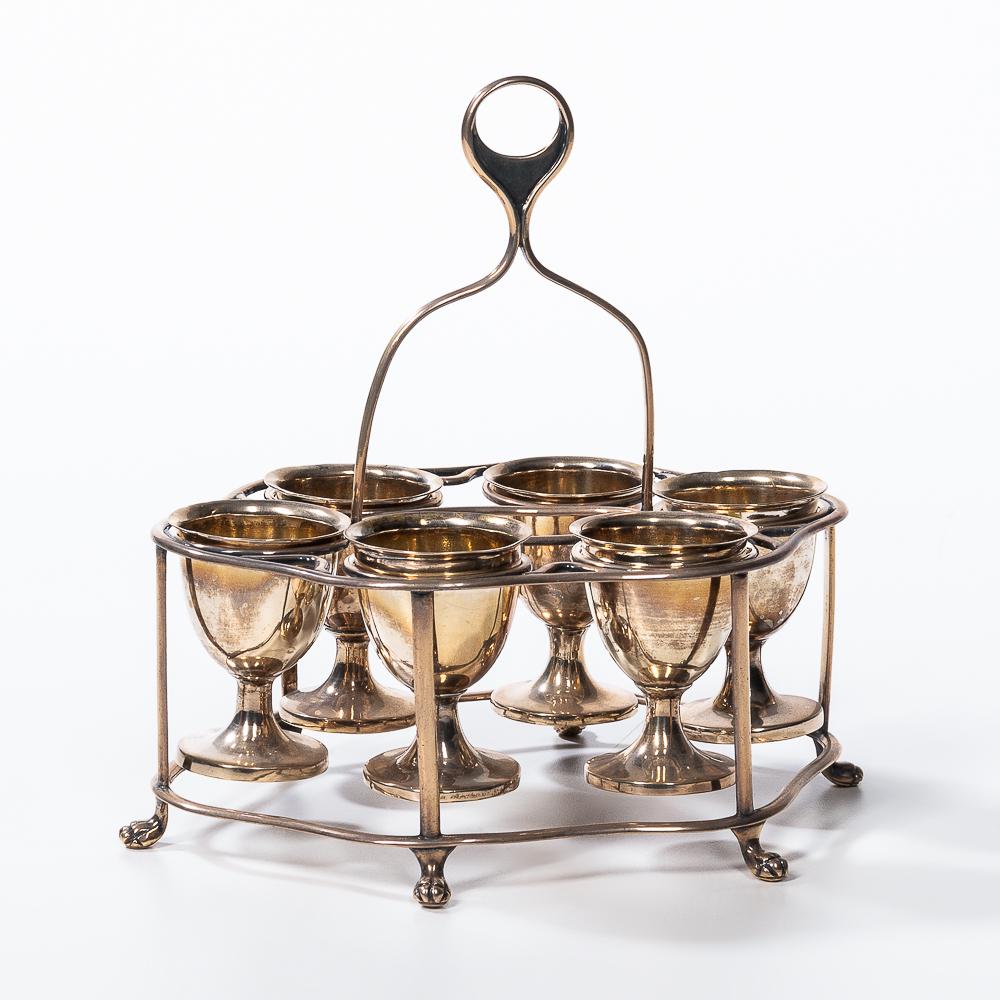 Sterling Six Egg Cruet, William Henry Twentyman, Calcutta, India, c. 1820s, the six egg cups with: Sterling Six Egg Cruet, William Henry Twentyman, Calcutta, India, c. 1820s, the six egg cups with flaring rims and round bases held within a carrier with central loop handle and claw and ball feet, th