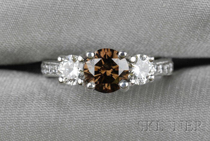Platinum, Colored Diamond, and Diamond Solitaire, : Platinum, Colored Diamond, and Diamond Solitaire, set with a full-cut fancy brown diamond weighing approx. 1.05 cts., flanked by full-cut diamonds and full-cut diamond melee, approx. total wt. 2.00 ct