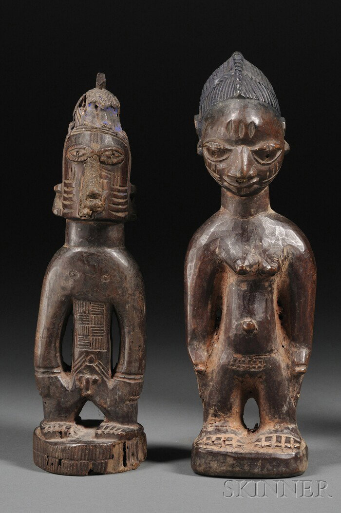 Two Yoruba Carved Wood Ibejis, the female with ridg: Two Yoruba Carved Wood Ibejis, the female with ridged coiffure, the male with scarification marks on front and back, ht. to 8 3/4 in.