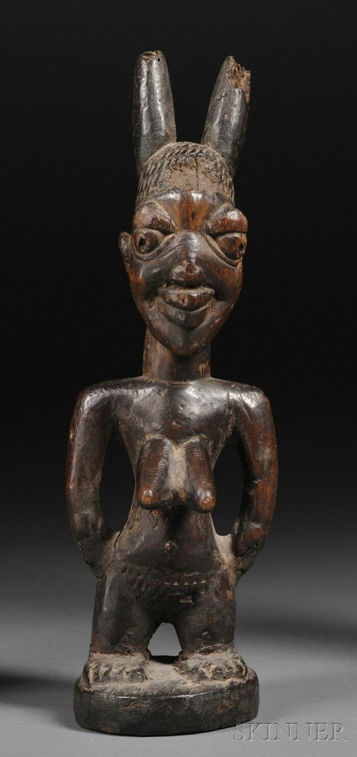 Yoruba Carved Wood Ibeji, the female form with hand: Yoruba Carved Wood Ibeji, the female form with hands to the sides and two-horned coiffure, ht. 10 1/2 in.