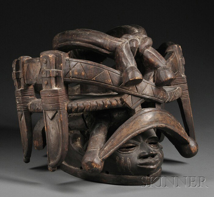 African Carved Wood Mask, Yoruba Gelede, helmet for: African Carved Wood Mask, Yoruba Gelede, helmet form, with protruding face and wearing an elaborate headdress with a sash that has four sheathed knives, ht. 12 1/2, dia. 17 in.