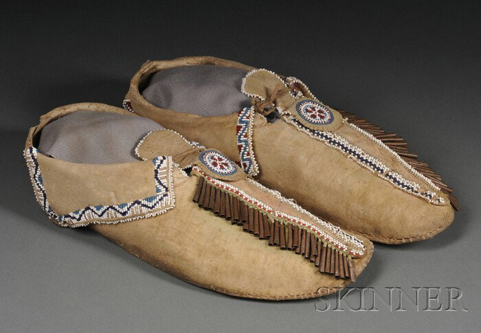 Pair of Comanche Beaded Hide Moccasins, c. early 2: Pair of Comanche Beaded Hide Moccasins, c. early 20th century, the hard-sole forms partially beaded and with one row of copper cones down the vamp, traces of red and green pigment, lg. 11 in.