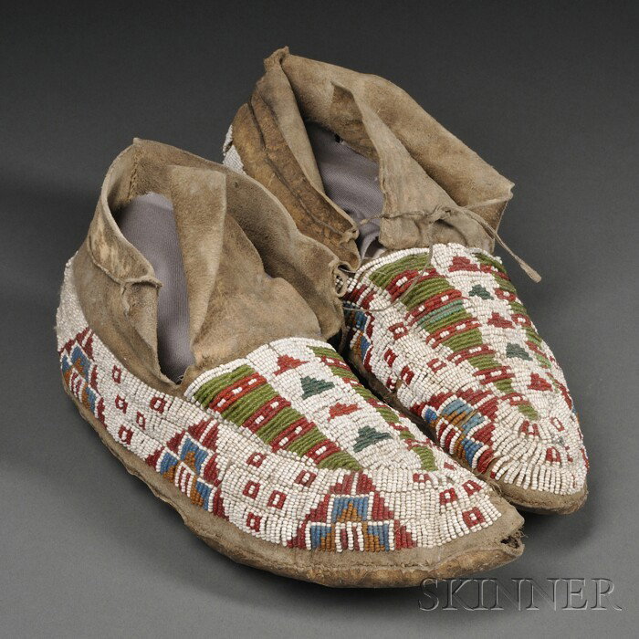 Lakota Beaded Hide Moccasins, c. 1900, with hard s: Lakota Beaded Hide Moccasins, c. 1900, with hard soles, the uppers beaded in geometric designs using multicolored seed beads, (bead loss, damage), lg. 10 in. Provenance: Collected by Mrs. Luke C. Walk