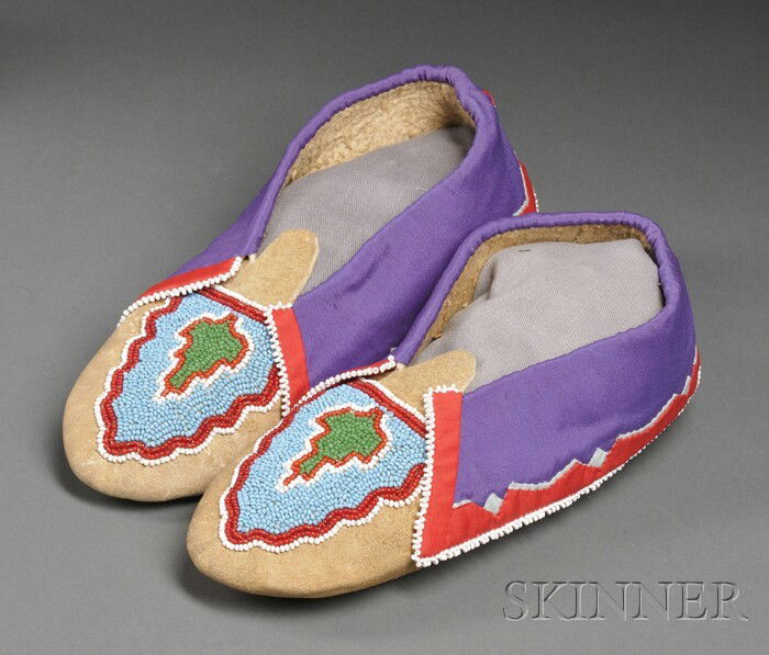 Delaware Beaded Hide Moccasins, c. 1930s, made by: Delaware Beaded Hide Moccasins, c. 1930s, made by Minnie Fouts, the vamps with beaded abstract foliate design, the cuffs with silk applique and white edge beading, lg. 9 in. Provenance: Dr. Frank T. S