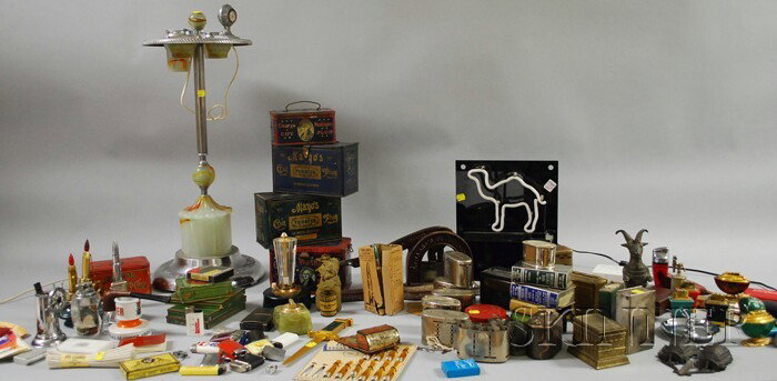 Art Moderne Illuminated Opaque Glass-mounted Chro: Art Moderne Illuminated Opaque Glass-mounted Chrome Smoking Stand and a Collection of Tobacco and Cigarette Tins, Vintage Lighters, a Tobacco Cutter, Collectibles, and a Group of Seventeen Still Banks