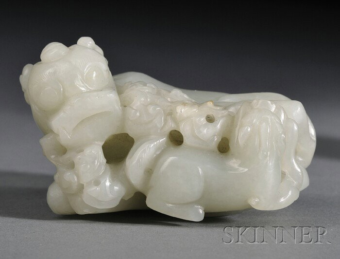 Jade Carving, China, a recumbent foo dog holding l: Jade Carving, China, a recumbent foo dog holding lingzhi sprigs in its mouth, the stone of gray-celadon color, lg. 2 3/4 in.