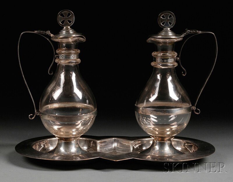 Pair of George V Silver-mounted Colorless Glass E: Pair of George V Silver-mounted Colorless Glass Ecclesiastic Ewers, London, 1925, ARM & Co., Ltd., makers, each with Maltese cross finial and angular handle, teardrop-shaped body and circular foot, on
