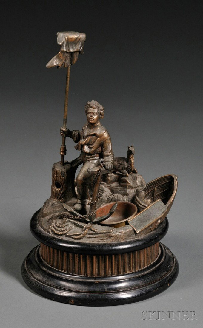 Gilt-metal Cigar Cutter, 19th century, cast as a s: Gilt-metal Cigar Cutter, 19th century, cast as a shipwrecked Robinson Crusoe, with a white flag bearing his name, ship's anchor, and llama, on fluted base and circular socle, with cutter in trunk at b