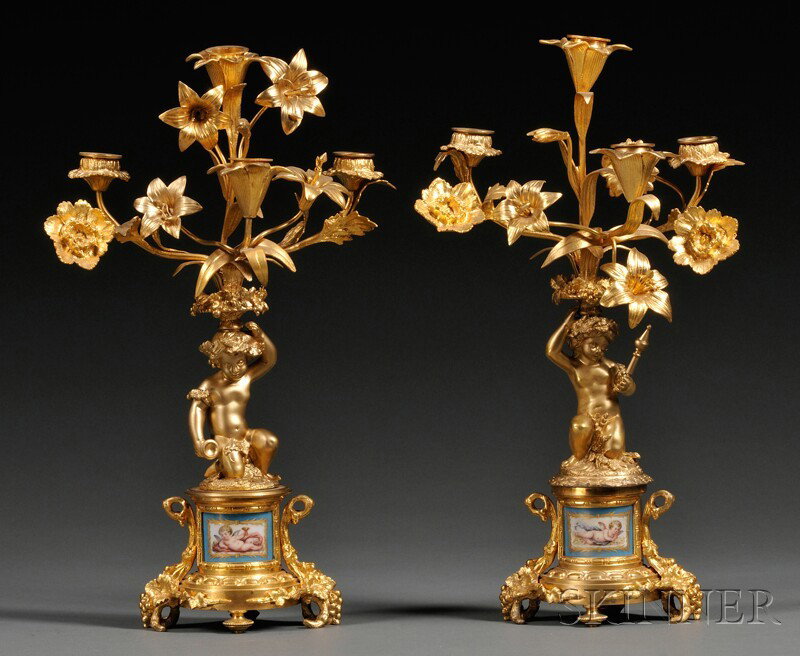 Pair of Sevres-style Porcelain Mounted Dore Bronz: Pair of Sevres-style Porcelain Mounted Dore Bronze Candelabra, France, early 20th century, each with four floral nozzles among floral stems mounted atop cherubs kneeling on raised bases set with porce