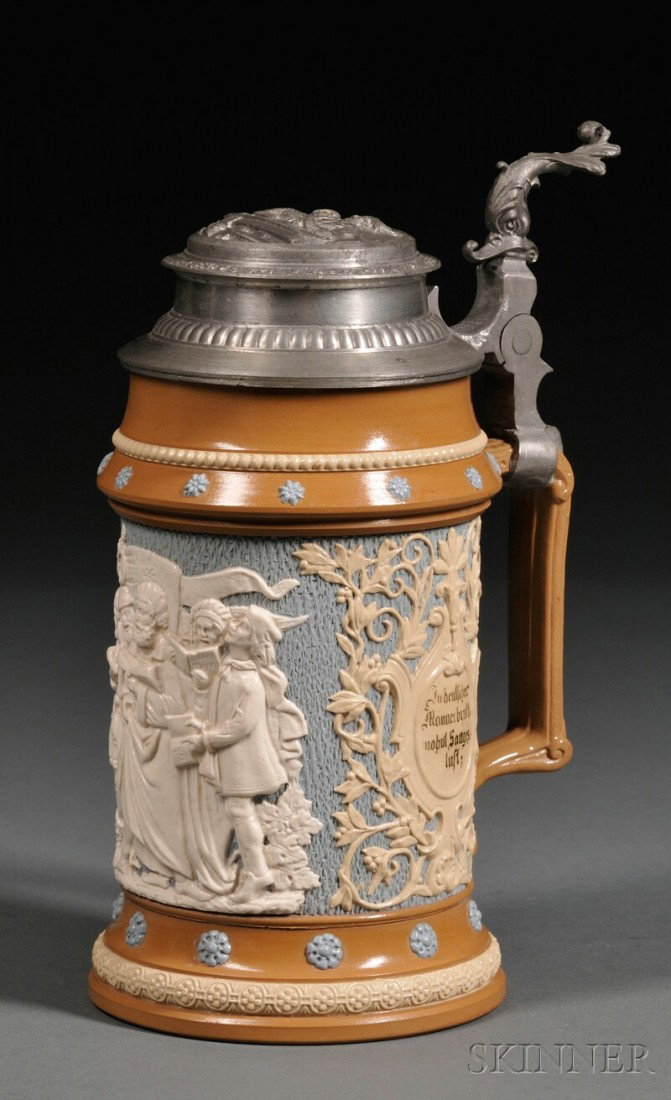 Pewter Mounted Mettlach Stein, Germany, c. 1885, : Pewter Mounted Mettlach Stein, Germany, c. 1885, 1/2 litre in relief with white relief of a group of men singing applied to a pale blue background, numbered 202 and impressed mark, ht. 7 3/4 in.