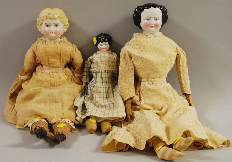 Three China Shoulderhead Dolls, Germany, late 19th: Three China Shoulderhead Dolls, Germany, late 19th century, one black center-part, ht. 22; blond with bangs, stitched-on boots, ht.19; black low-brow "Ruth", ht. 13 in.