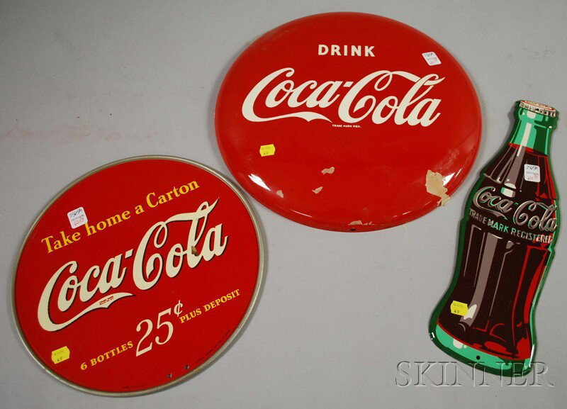 Three Coca-Cola Painted Tin Signs, c. 1940-52, a d: Three Coca-Cola Painted Tin Signs, c. 1940-52, a display, a bottle-form, and a button, (unused), dia. 13, lg. 16 3/4, dia. 16 in., respectively.