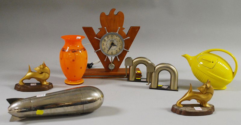 Eight Art Deco and Mid-century Design Articles, in: Eight Art Deco and Mid-century Design Articles, including metal stylized elephant bookends, Scottie dog bookends, a Howard metal ship's wheel and maple "victory" mantel clock, a Henckels zeppelin cock