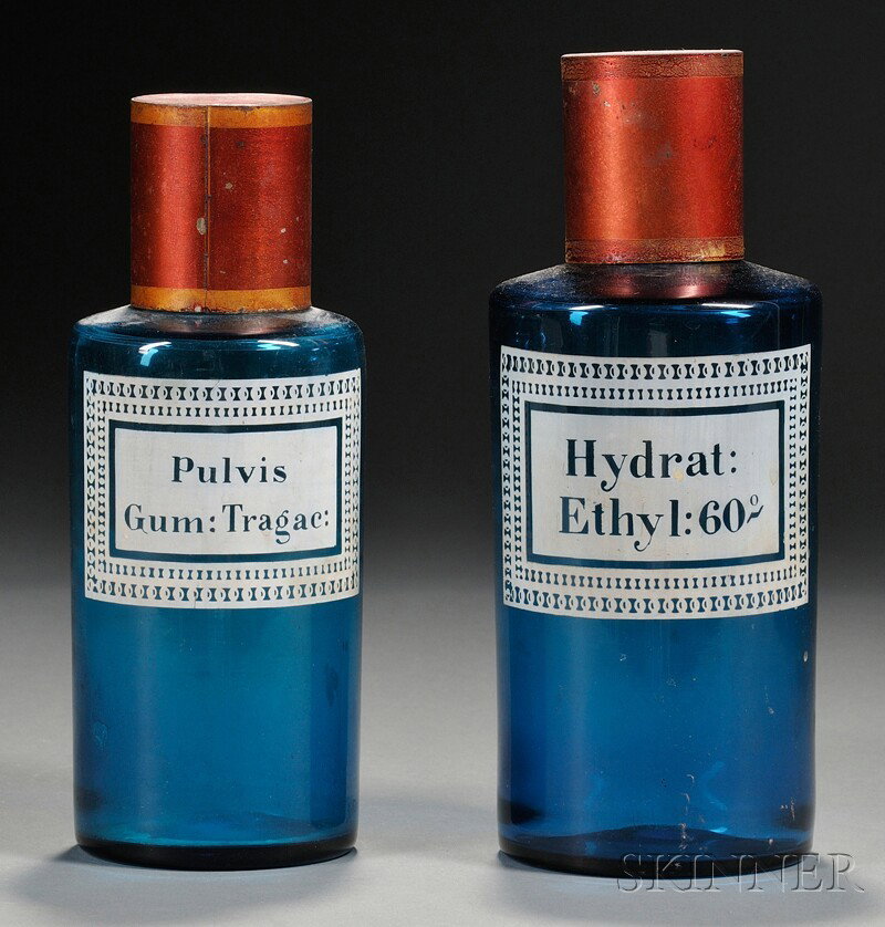 Two Dark Aqua Blue Glass Apothecary Jars, America,: Two Dark Aqua Blue Glass Apothecary Jars, America, 19th century, cylindrical blown glass jars with polished pontils, white enamel stenciled content labels: "Pulvis Gum Tragac" and "Hydrat Ethyl 60," w