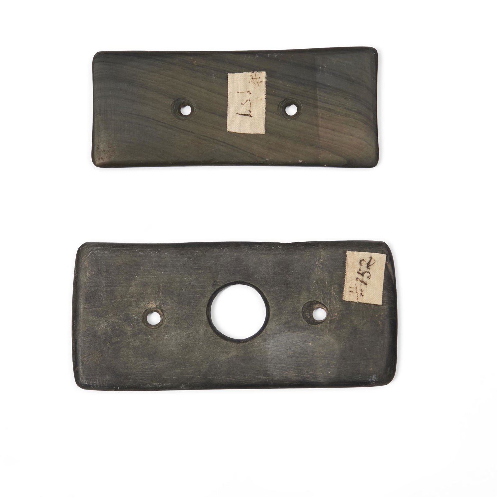 Two Prehistoric slate gorgets lg. 4 1/4, wd. 1 7/8, and lg. 3 3/4, wd. 1 1/2 in.: Two Prehistoric slate gorgets The larger rectangular with a large central hole and two smaller bi-conical holes, the second a banned slate example with two bi-conical holes, with paper label, 'Gorget