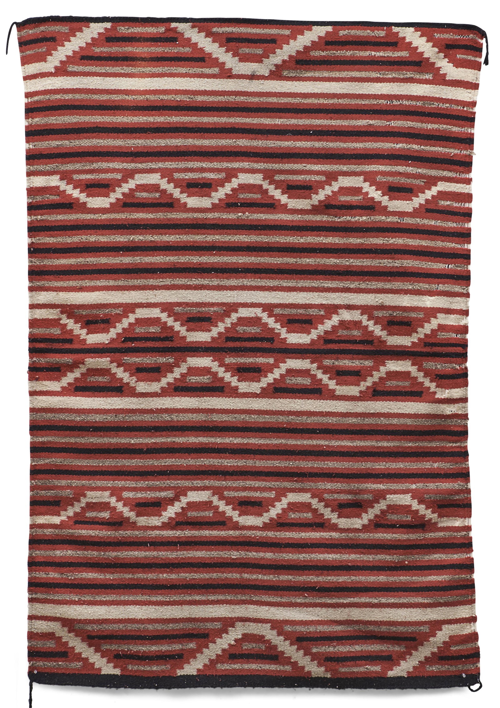 A Navajo (Diné) regional rug 67 1/2 x 47 in.: A Navajo (Diné) regional rug The dark border surrounds three vertical rows of serrated diamond devices, on a variegated gray/brown ground. 67 1/2 x 47 in.