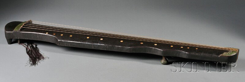 Lacquered Zither, China, black and green lacquer w: Lacquered Zither, China, black and green lacquer with thirteen inlaid mother-of-pearl round markers and seven strings, resting on four feet with gilded inscription on base, lg. 47 1/4 in.
