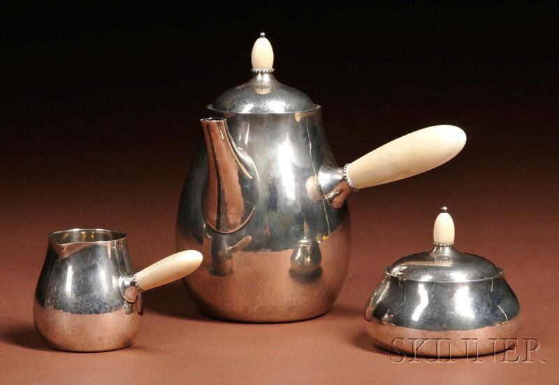 Georg Jensen Coffee, Covered Sugar, and Creamer Sterling silver Denmark, after 1945 Hammered bulbous: Georg Jensen Coffee, Covered Sugar, and Creamer Sterling silver Denmark, after 1945 Hammered bulbous forms with ivory finials and handles, marked Georg Jensen in a beaded oval, Denmark, Sterling 80A, 