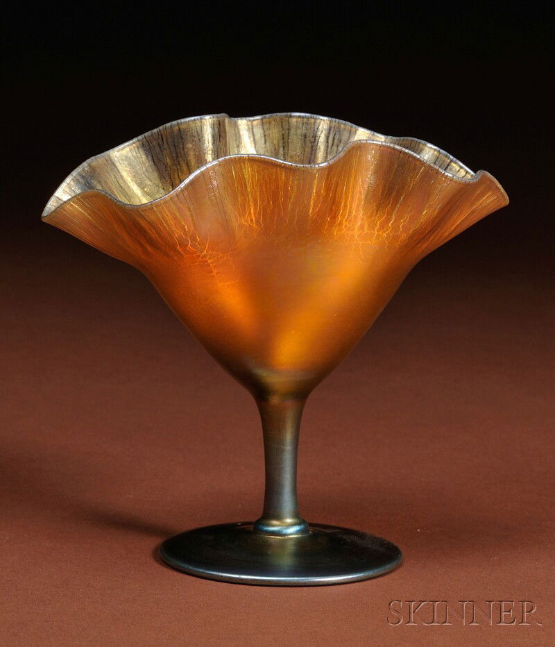 Steuben Gold Aurene Floriform Vase Art glass Corning, New York Oval form with ruffled rim of stretch: Steuben Gold Aurene Floriform Vase Art glass Corning, New York Oval form with ruffled rim of stretched gold iridescent glass on cylindrical stem raised on circular foot, marked Aurene 2761, ht. 6 in.