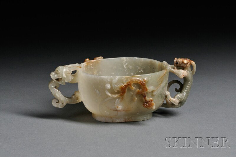 Jade Cup, China, 19th century, the exterior of the: Jade Cup, China, 19th century, the exterior of the cup with relief carving of chi dragons, with another chilong as the handle, and a dragon-head handle, stone of semi-translucent celadon color with ru