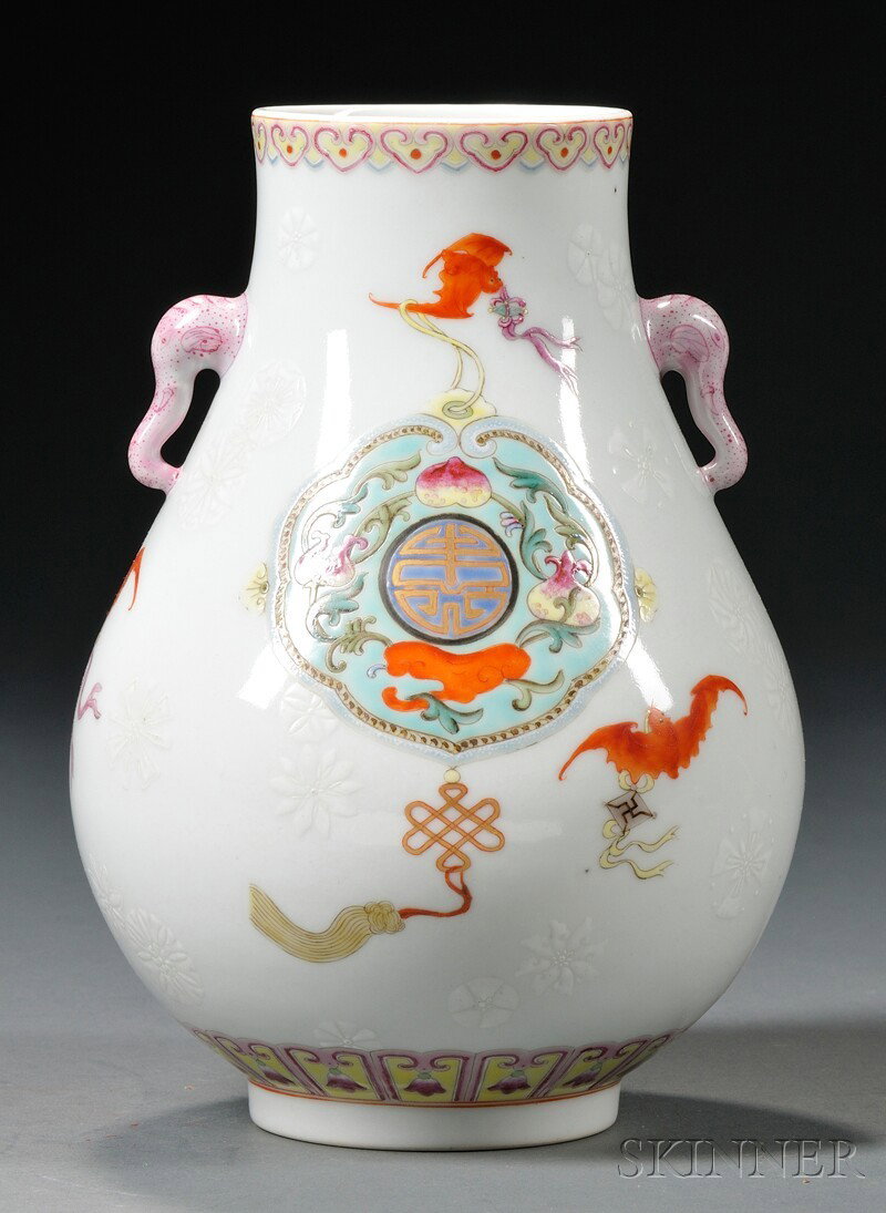 Porcelain Vase, China, decorated with auspicious: Porcelain Vase, China, decorated with auspicious symbols within two cartouches on a white ground with white relief stylized flowers and bats, elephant handles, Qianlong mark on base, ht. 8 1/2 in.