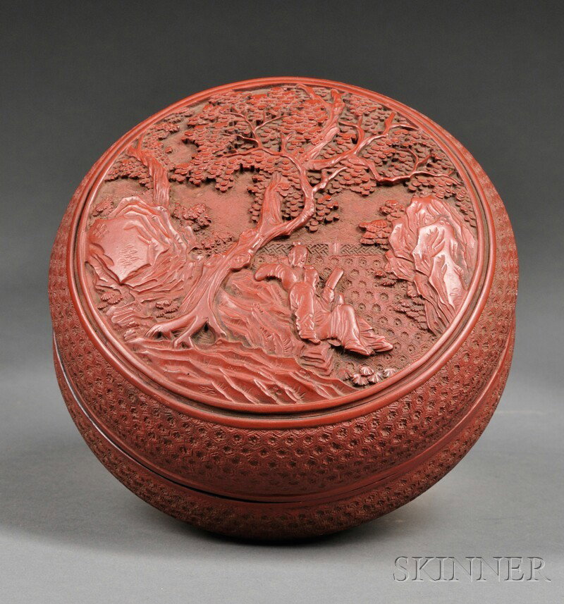 Cinnabar Box and Cover, China, the cover of the c: Cinnabar Box and Cover, China, the cover of the circular box carved in relief with two scholars reading under a pine tree, geometric patterns to the sides, Qianlong mark to the base, dia. 7 in.