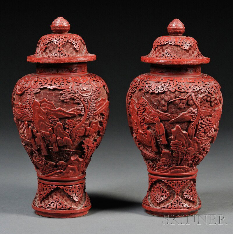 Pair of Cinnabar Covered Vases, China, of baluste: Pair of Cinnabar Covered Vases, China, of baluster shape decorated with Immortals in mountain landscape, lotus reserves at base with key fret and lotus border on shoulder and domed cover, lotus finial