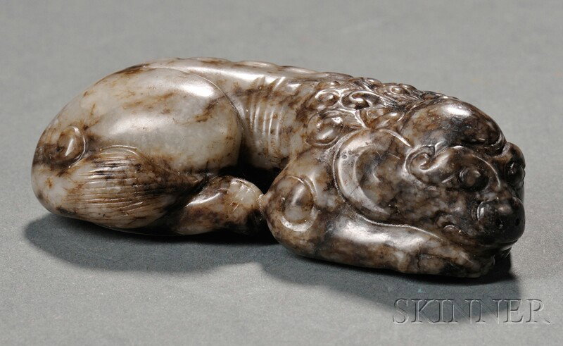 Jade Carving, China, 19th century, finely carved : Jade Carving, China, 19th century, finely carved as a recumbent foo dog, the stone of white color with dark markings, lg. 2 3/8 in.