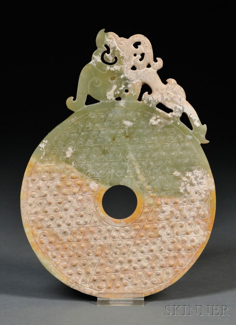 Jade Plaque, China, circular green and pale amber: Jade Plaque, China, circular green and pale amber with a C-scroll ground with stylized dragon on top, dia. 6 3/4, lg. 9 in.