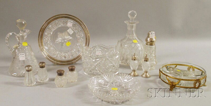 Thirteen Colorless Cut Glass Table Articles, an i: Thirteen Colorless Cut Glass Table Articles, an ice bucket, two decanters, three pairs of shakers, a caster, a sterling silver-rimmed plate, a low bowl, and a gilt-metal mounted divided dish.