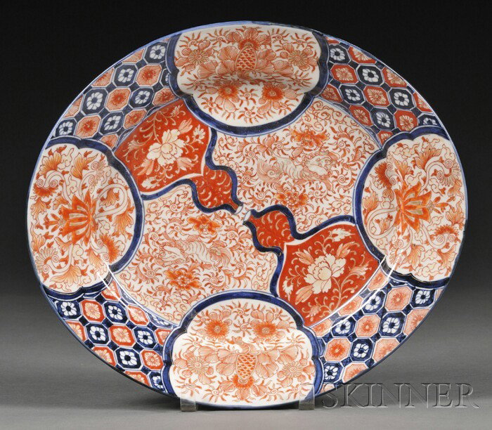 Imari Oval Platter, Japan, late 19th century, pai: Imari Oval Platter, Japan, late 19th century, painted in red, blue, and gilt with cartouches of a composite of flowers, and foo dogs, floral spray in underglaze blue to the exterior, 14 3/4 x 13 in.