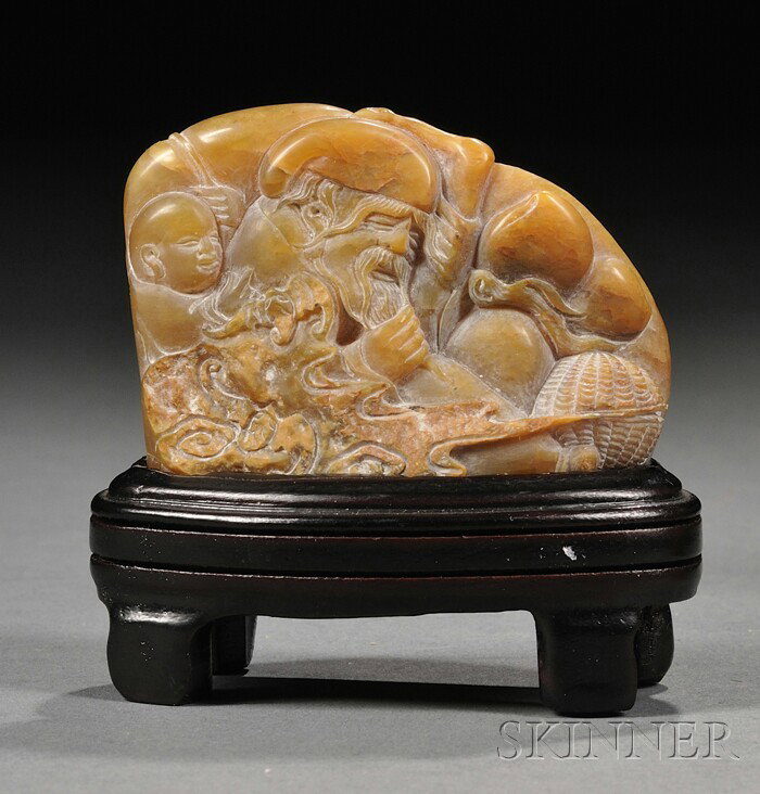 Soapstone Seal, China, finely carved in relief as: Soapstone Seal, China, finely carved in relief as Shoulao holding peach sprigs, and his attendant holding a fly whisk extending to the back, wood stand, 2 1/4 x 1 3/4 in.