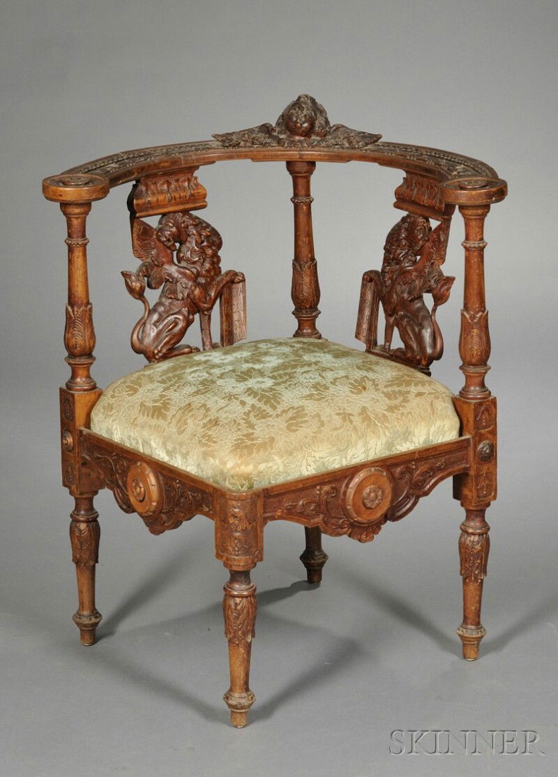 Italian Carved Walnut Corner Chair, with putti cres: Italian Carved Walnut Corner Chair, with putti crest and griffin-form splats, above over-upholstered slip seat, carved chair rail, and baluster-form legs, on circular feet, seat ht. 18 in.