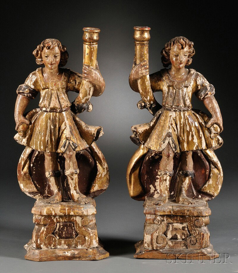 Pair of Figural Carved, Polychrome, and Giltwood Ca: Pair of Figural Carved, Polychrome, and Giltwood Candlesticks, each with a standing figure in a short cloak and sandals, holding a cornucopia with a candlecup at the end, on carved base, ht. 23 1/2 in