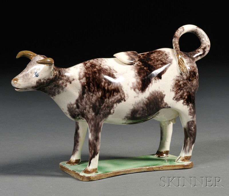 Staffordshire Earthenware Cow Creamer, England, c.: Staffordshire Earthenware Cow Creamer, England, c. 1800, the standing figure decorated with a mottled gray/black sponging and mounted atop a translucent green base, lg. 7 7/8 in.
