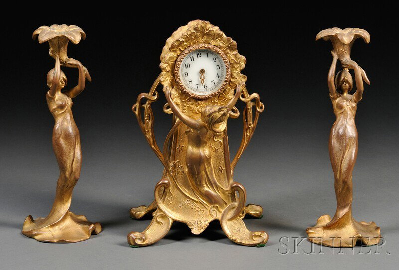New Haven Clock Co. Art Nouveau Gilt-metal Figural: New Haven Clock Co. Art Nouveau Gilt-metal Figural Table Clock and a Pair of Candlesticks, (missing one dial hand), ht. 12 3/4, 11 3/4 in.