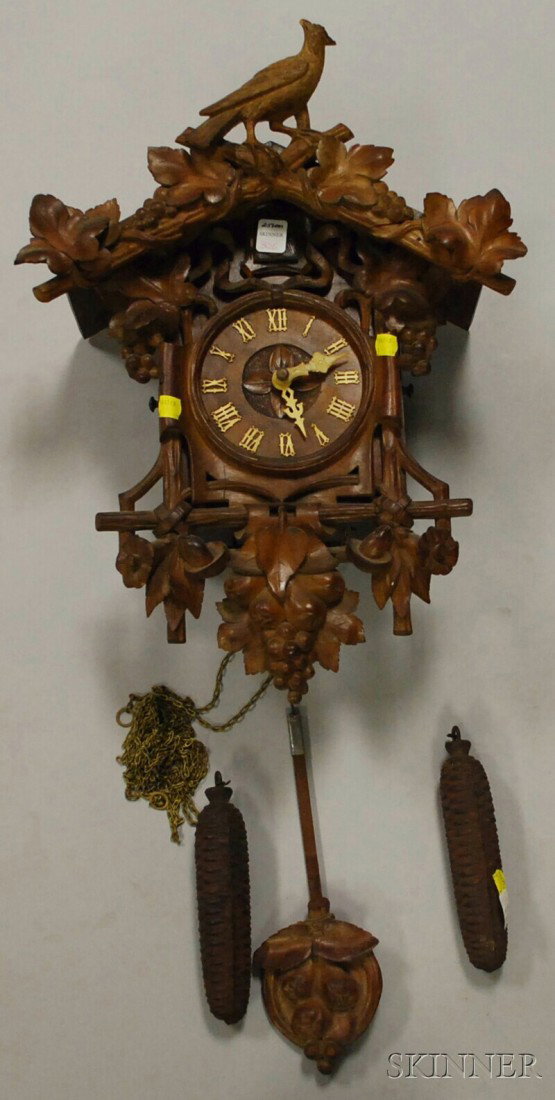 Black Forest Cuckoo Clock, with thirty-hour wood-f: Black Forest Cuckoo Clock, with thirty-hour wood-frame and brass wheel weight-powered movement, acorn-carved pendulum and two iron acorn weights, ht. 22 in.