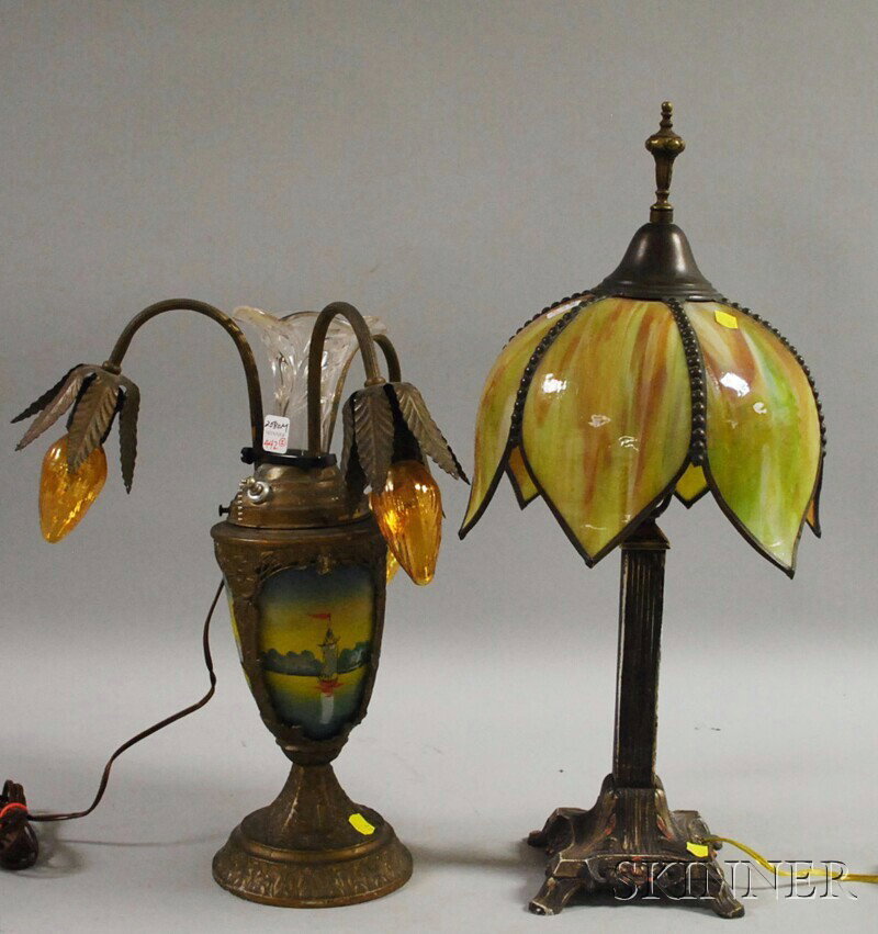 Two Early 20th Century Art Glass and Metal Table L: Two Early 20th Century Art Glass and Metal Table Lamps, an Edison bent slag glass panel floral-form and painted cast metal lamp and a metal and reverse-painted glass three-light table lamp.