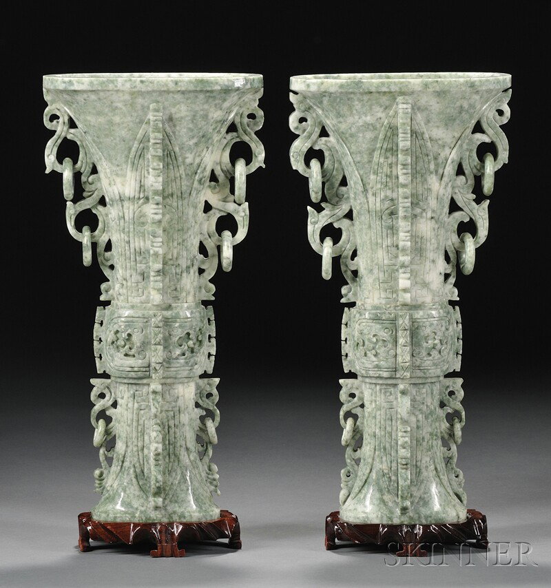 Pair of Hardstone Vases, China, 20th century, of g: Pair of Hardstone Vases, China, 20th century, of gu shape with incised leaves, the central section with taotie masks, both sides with flanges and S-curve scrolls and rings, stands, ht. 12 3/8 in.