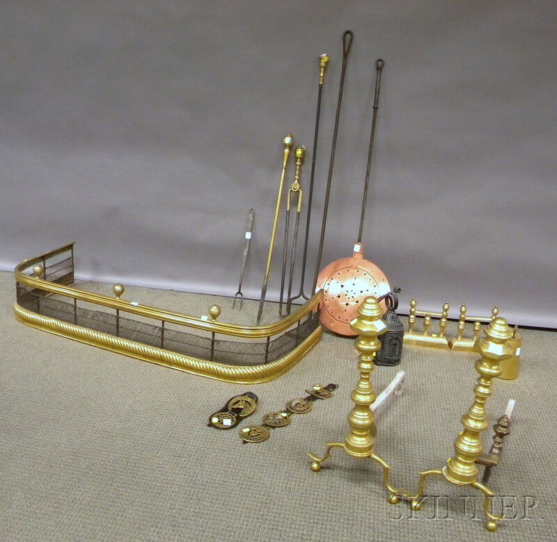 Group of Brass and Iron Fireplace and Hearth Item: Group of Brass and Iron Fireplace and Hearth Items and Decorative Accessories, including brass ring-turned andirons, tool rests, a Cape Cod lighter, a brass and wire fender, six horse brasses, brass-h