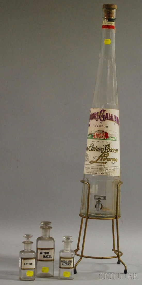 Colorless Glass Bottle-form Liquor Dispenser with: Colorless Glass Bottle-form Liquor Dispenser with Spigot and Metal Stand and Three Apothecary Bottles with Stoppers.