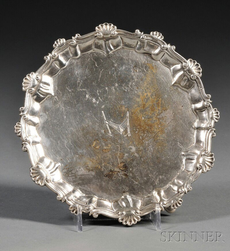 Small George III Silver Salver, London, 1764, Ebene: Small George III Silver Salver, London, 1764, Ebenezer Coker, maker, of typical form, the round salver with shaped shell and C-scroll piecrust edge, engraving to field, raised on three cabriole legs t
