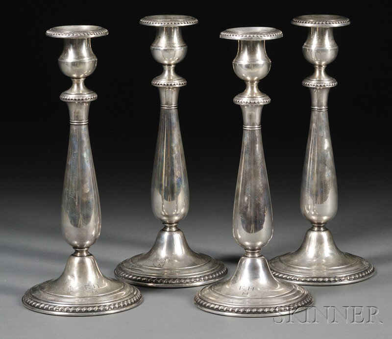 Set of Four Cartier Weighted Sterling Candlesticks: Set of Four Cartier Weighted Sterling Candlesticks, 20th century, the tapered baluster-form candlesticks with gadrooned sconce, knop, and spreading foot, monogrammed to base, ht. 10 1/4 in.