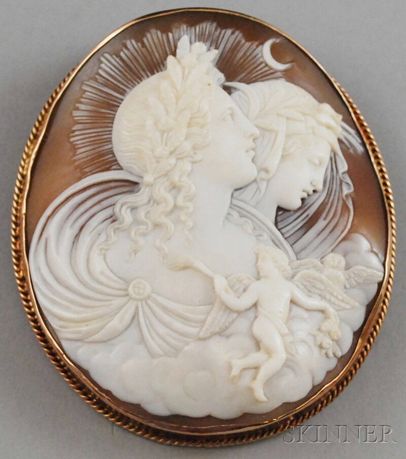 10kt Gold-framed Shell-carved Cameo Brooch, with f: 10kt Gold-framed Shell-carved Cameo Brooch, with finely detailed carving depicting two classical goddesses or women emerging from clouds, with small figures of a cherub and an owl at the bottom right 