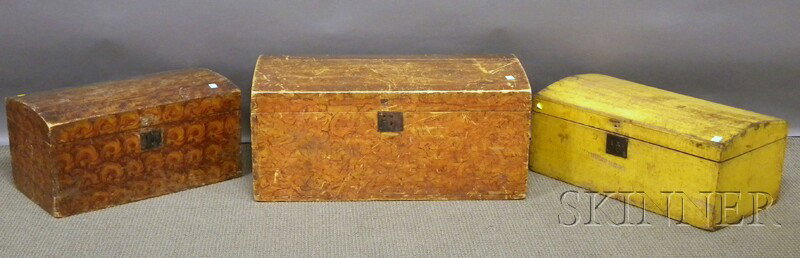 Three Paint-decorated Wooden Dome-top Trunks, two: Three Paint-decorated Wooden Dome-top Trunks, two grain-painted pine dovetail-constructed dome-top trunks, and a yellow-painted wood dovetail-constructed trunk, the two larger lg. 33 and 27 in. Proven