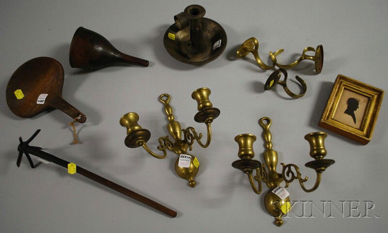 Eight Early Small Household Items and a Framed Sil: Eight Early Small Household Items and a Framed Silhouette, 19th century, a pair of brass two-light wall-mounted candle sconces, two curved brass jamb hooks, a tin chamberstick with snuffer, a carved m